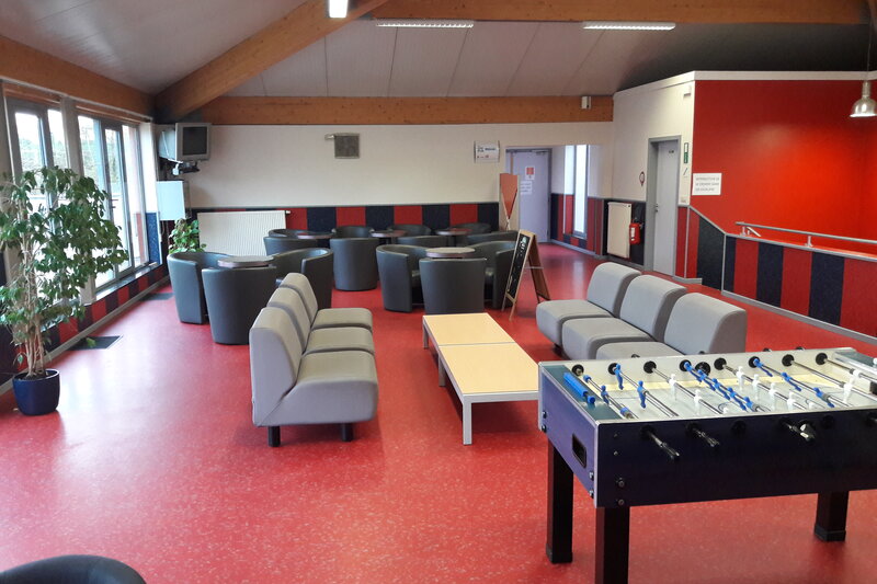 Salle de détente avec canapés et kicker au centre d’hébergement